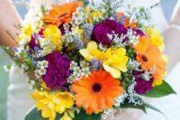 a bold wedding bouquet of orange gerberas, purple and yellow blooms, leaves and fillers is a cool idea for a bold wedding