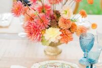 a bold wedding centerpiece of an urn with pink, orange, peachy adnd yellow dahlias is a cool idea for summer or fall
