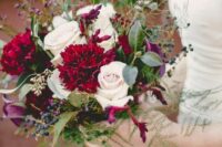 a bright and catchy wedding bouquet of blush roses and burgundy carnations and callas, textured greenery and leaves plus berries