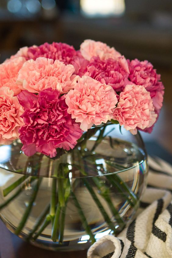 a bright and cool carnation wedding centerpiece of fuchsia and pink blooms in a clear bowl is a lovely idea