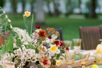 a bright and textured wedding centerpiece with greenery, blush and white blooms, rust and yellow carnations and dahlias is a spectacular thing