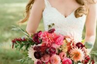 a bright wedding bouquet of pink and purple raunuculus and pink and white dahlias, greenery and pink ribbons for an accent