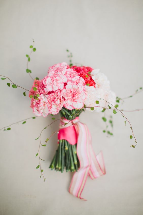 a bright wedding bouquet of white, pink and hot pink carnations, greenery and pink ribbons can be easily DIYed
