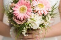a catchy wedding bouquet of pink roses and gerberas, greenery and lily of the vally is a lovely idea for spring and summer
