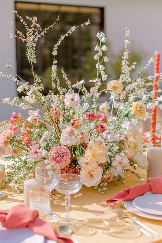 a cheerful wedding centerpiece of white, blush and pink and yellow blooms including carnations and peonies is a lovely idea for summer
