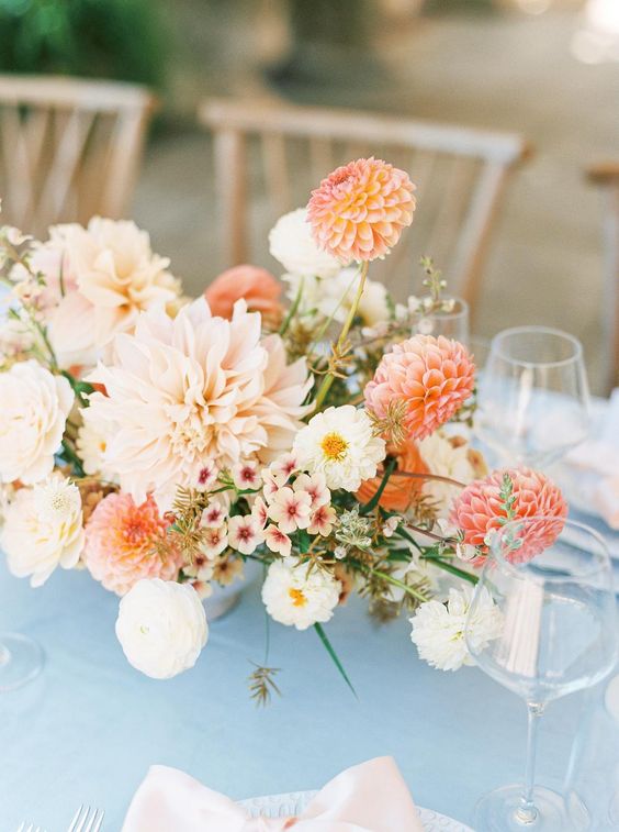 a chic summer wedding centerpiece of blush, coral and white dahlias, fillers and greenery is a cool idea
