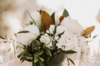 a classic southern wedding centerpiece of greenery, white hydrangeas and peonies, greenery and magnolia leaves