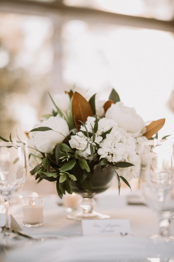 a classic southern wedding centerpiece of greenery, white hydrangeas and peonies, greenery and magnolia leaves