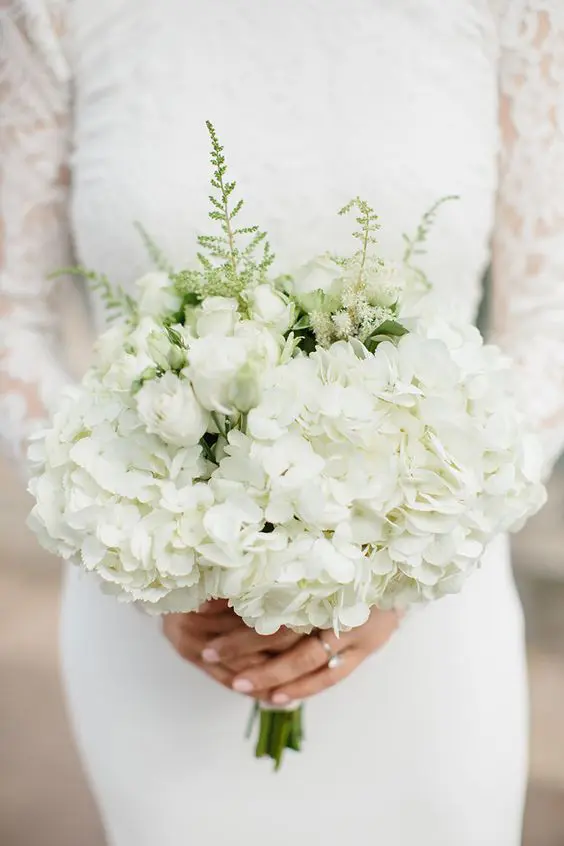 a classic white wedding bouquet of white roses and hydrangeas and some fillers for a more textural look
