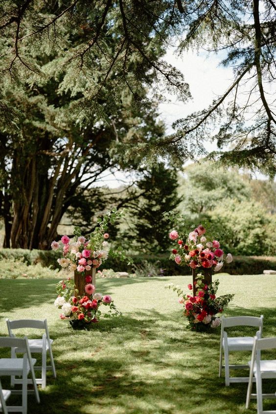 a colorful wedding altar of white hydrangeas, pink and red dahlias is a lovely idea for a summer wedding