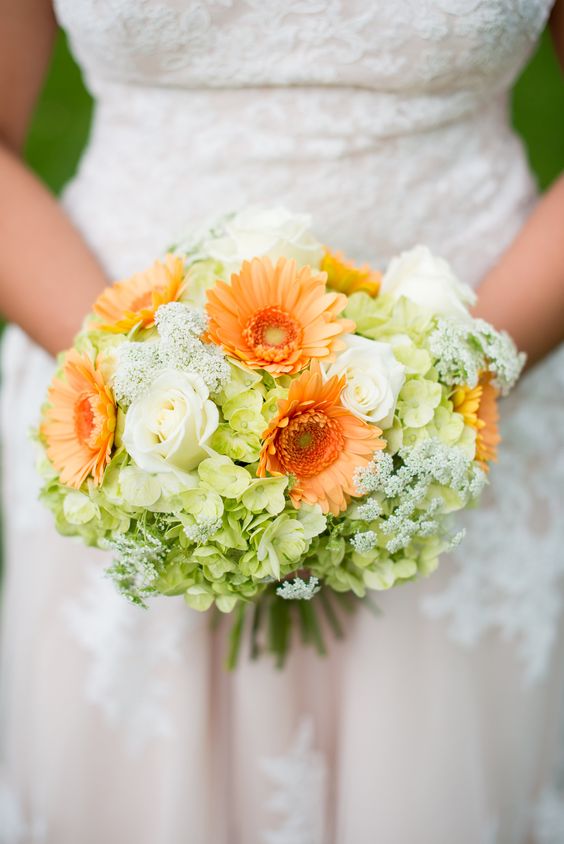 a colorful wedding bouquet of white roses, orange gerberas, green hydrangeas and some fillers is a cool idea