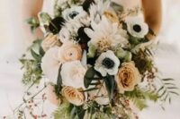 a cool wedding bouquet of rust roses and ranunculus, dark blooms, white anemones and dahlias, greenery and berries