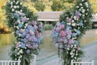 a creative wedding altar shaped as butterfly wings, with greenery, white roses and lilac and blue hydrangeas is a gorgeous idea