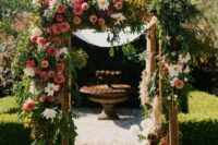 a creative wedding arch done with lush greenery, white, pink and rust-colored dahlias looks very eye-catching and will match and bold wedding