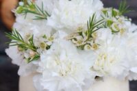 a creative wedding centerpiece of a sphere vase with white carnations and waxflowers is a lovely idea for a modern wedding