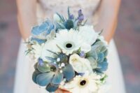 a delicate and stylish wedding bouquet of white gerberas, baby’s breath, succulents, thistles and purple touches is chic
