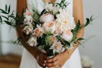 a delicate blush wedding bouquet of dahlias and peony roses and greenery will do for a spring or summer wedding