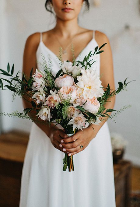 a delicate blush wedding bouquet of dahlias and peony roses and greenery will do for a spring or summer wedding