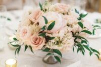 a delicate blush wedding centerpiece of roses, peonies, hydrangeas and greenery plus candles around is a lovely idea