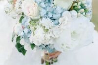 a delicate wedding bouquet featuring blue hydrangeas, ligth pink roses, lush white peonies is a beautiful idea for a summer wedding