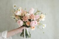 a delicate wedding bouquet of blush and white roses, blush caranations and white fillers, some neutral ribbons is wow
