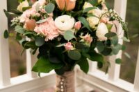 a delicate wedding bouquet of blush roses and carnations, white ranunculus and greenery is a chic idea for spring or summer