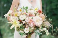 a delicate wedding bouquet of pink and blush dahlias, lilies, some other blooms and greenery for a summer wedding