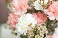 a delicate wedding centerpiece of blush and white carnations and waxflower is a cool and lovely idea for spring or summer