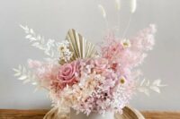 a delicate wedding centerpiece with dried and fresh roses, daisies, hydrangeas, bunny tails, fronds and leaves is amazing