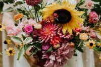 a dreamy summer wedding bouquet with pink, blush, orange blooms and sunflowers plus some foliage is a cool idea for a relaxed summer bride