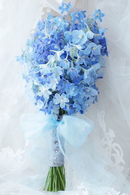 a fab light and bold blue wedding bouquet with a light blue rap and some pearl pins is a very stylish and cool diea