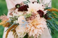 a fall wedding bouquet of blush roses and dahlias, burgundy dahlias, greenery and fillers is a stylish idea