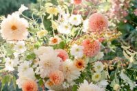 a fantastic dimensional wedding centerpiece of pink, coral and white dahlias of various kinds and lots of foliage
