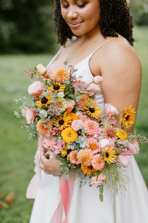 a fantastic pink and yellow dahlias and rose wedding bouquet with just a bit of greenery for a summer wedding