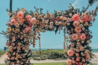 a fantastic wedding arch covered with greenery, white, lilac and pink blooms including pink peonies is a lovely solution
