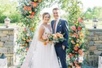 a fun and bright wedding arch covered with pink and coral peonies, yellow and blue blooms is a cool idea for a summer garden wedding