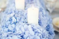 a gorgeous and super lush blue hydrangea wedding table runner with pillar candles is a fantastic idea for a wedding