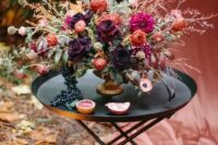 a gorgeous decandent wedding centerpiece with pink, orange, dark plum and blush blooms and textural greenery and branches