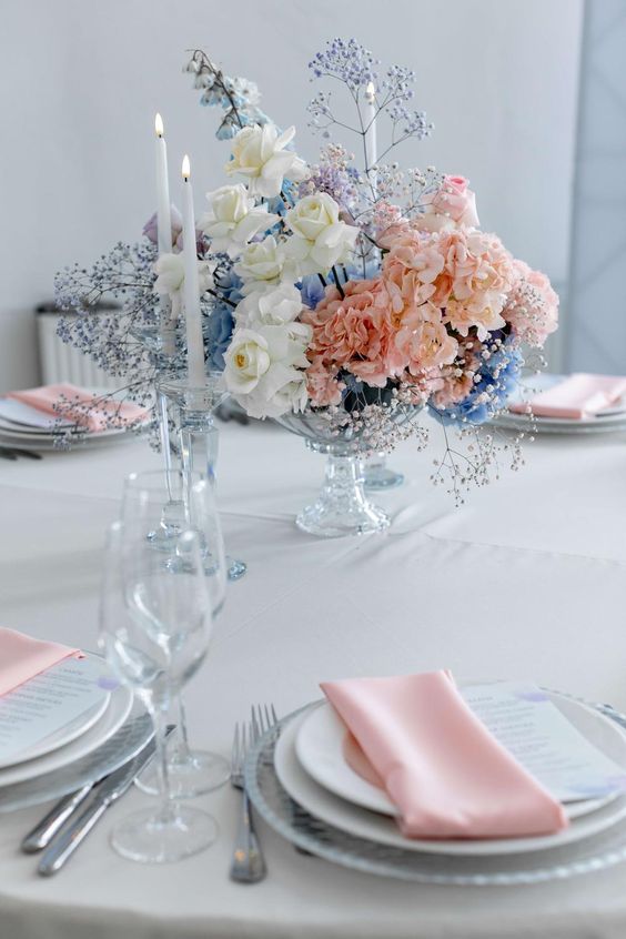 a gorgeous lush wedding centerpiece of white roses, pink hydrangeas, blue and purple baby's breath is a chic and cool idea