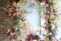 a gorgeous wedding arch with plenty of greenery, pink, red and blush blooms is a very beautiful and cool idea