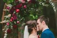 a hot red and pink and burgundy flower wedding arch with eucalyptus is a beautiful idea for a fall wedding