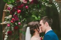 a hot red and pink and burgundy flower wedding arch with eucalyptus is a beautiful idea for a fall wedding