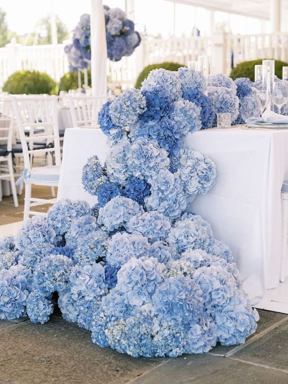 a jaw-dropping blue hydrangea wedding table runner that descends to the floor is a lovely idea for a wedding with a blue color palette