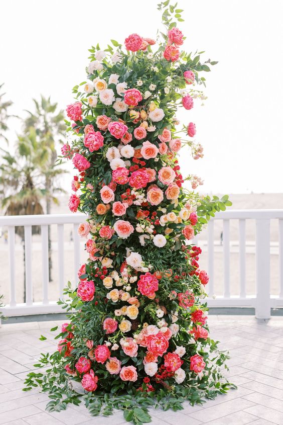 A jaw dropping wedding altar with greenery, white, blusha nd peachy roses and coral peonies is a fantastic statement