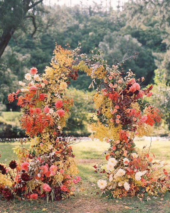a jaw-dropping wedding arch for the fall decorated with fall blooms, white, coral, blush and burgundy dahlias