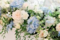 a lovely blue and white hydrangea wedding bouquet of peachy peony roses and roses, thistles and greenery for spring or summer