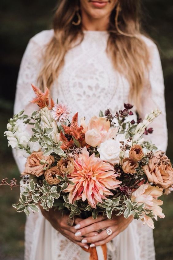 a lovely boho wedding bouquet of peachy dahlias and coffee-colored and white roses, greenery and some dried fillers