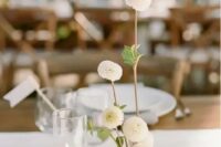 a lovely cluster wedding centerpiece of a couple of candles and white dahlias in a vase is a chic idea that you may realize yourself