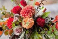 a lovely fall wedding centerpiece of orange, coral dahlias, mauve roses, berries and leaves is a cool idea for a bold celebration