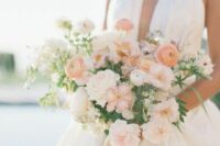 a lovely neutral and pastel wedding bouquet of blush carnations, white roses, peachy ranunculus and some greenery